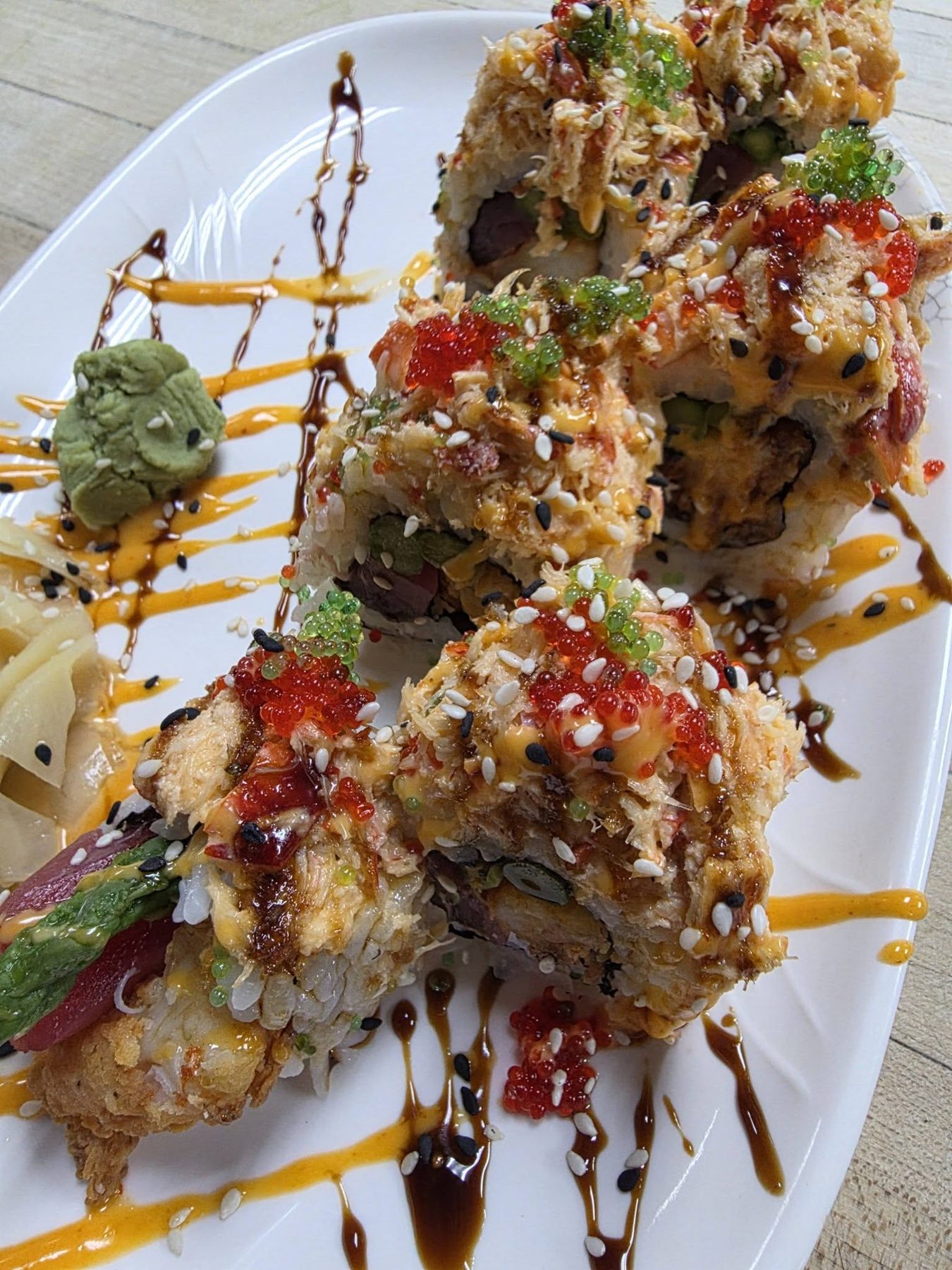 Colorful sushi roll topped with crab and roe