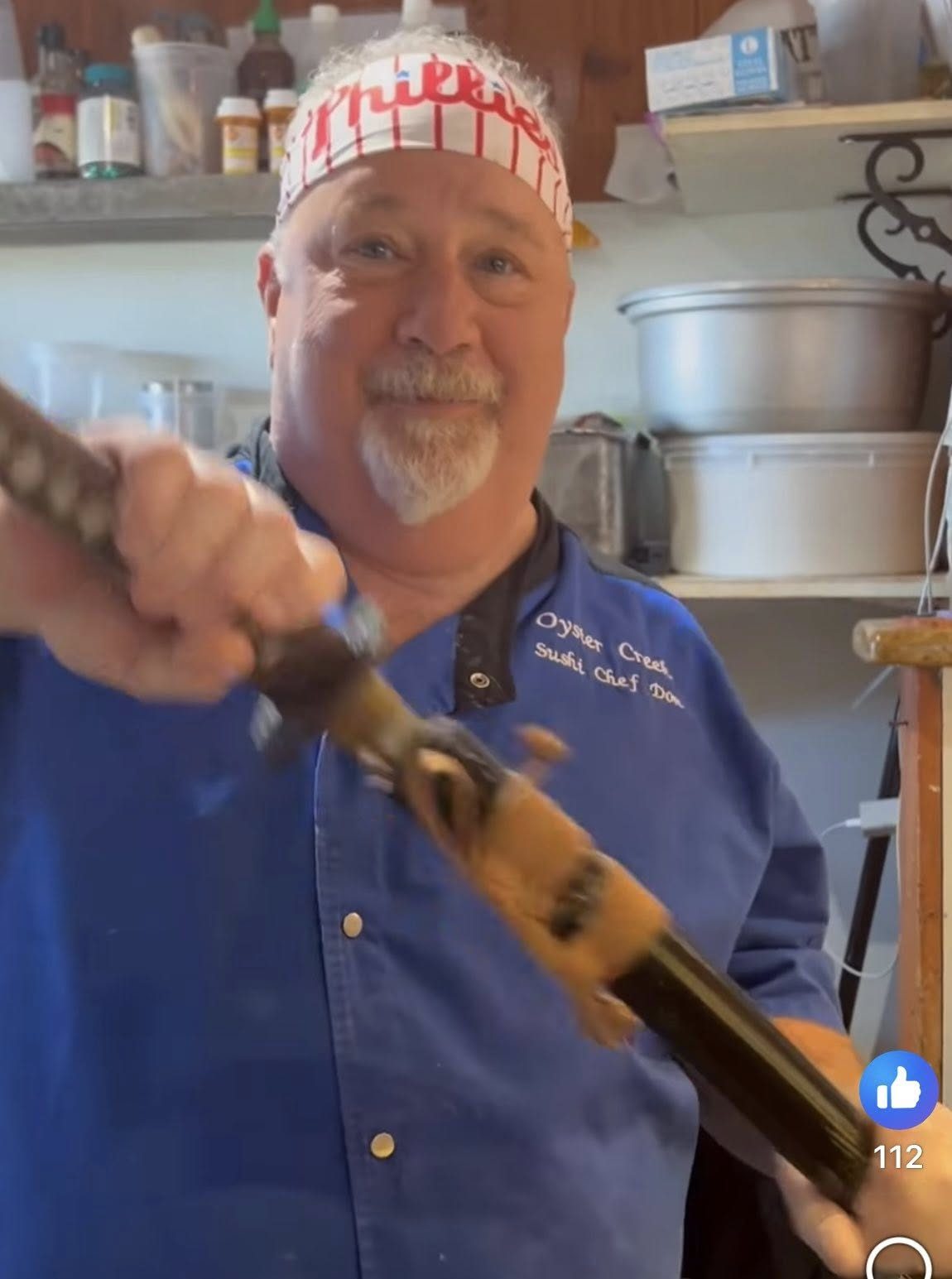 Chef Don pointing toward the camera in his sushi chef coat