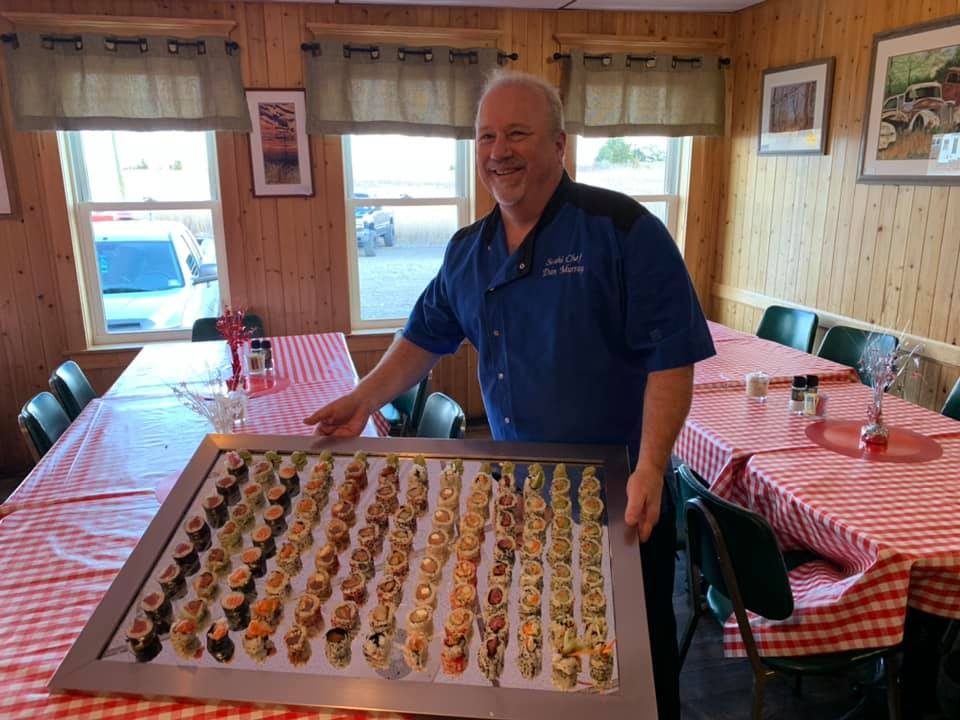 SushiDon Murray holding a large sushi tray